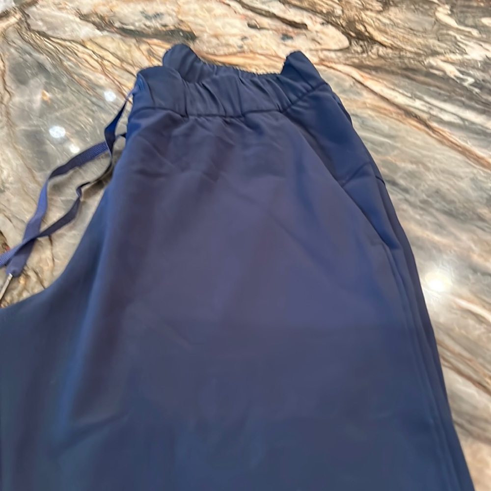 Navy blue joggers with tapered, leg, and side pockets.